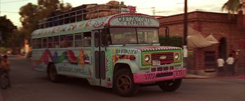 Movie still from “The Sisterhood of the Traveling Pants” (2005), directed by Ken Kwapis – A colorful bus is driving down the street; Wide shot, Low angle
