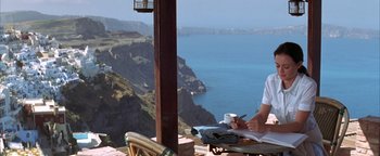 Movie still from “The Sisterhood of the Traveling Pants” (2005), directed by Ken Kwapis – A person sitting at a table writing on a book; Medium shot, High angle