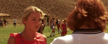 Movie still from “The Sisterhood of the Traveling Pants” (2005), directed by Ken Kwapis – A group of people standing on top of a grass covered field; Close Up shot, Over the shoulder angle