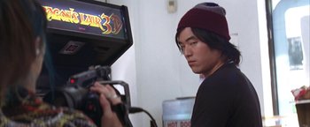 Movie still from “The Sisterhood of the Traveling Pants” (2005), directed by Ken Kwapis – A man in a beanie is filming a video; Close Up shot, Over the shoulder angle