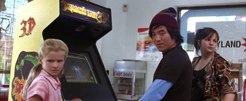 Movie still from “The Sisterhood of the Traveling Pants” (2005), directed by Ken Kwapis – A man standing in front of an arcade machine; Close Up shot, Over the shoulder angle