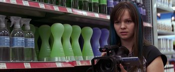 Movie still from “The Sisterhood of the Traveling Pants” (2005), directed by Ken Kwapis – A woman is taking a picture in a liquor store; Close Up shot, Over the shoulder angle