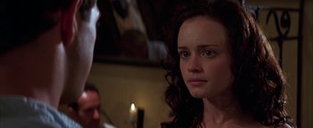 Movie still from “The Sisterhood of the Traveling Pants” (2005), directed by Ken Kwapis – A young woman with long curly brown hair stares into the distance; Close Up shot, Over the shoulder angle