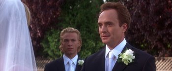 Movie still from “The Sisterhood of the Traveling Pants” (2005), directed by Ken Kwapis – A man in a suit stands next to another man in a suit; Close Up shot, Over the shoulder angle