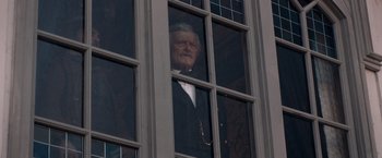 Movie still from “The Sisters Brothers” (2018), directed by Jacques Audiard – An older man looking out of a window; Medium shot, Low angle