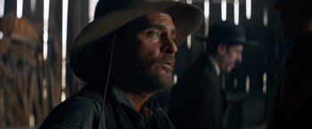 Movie still from “The Sisters Brothers” (2018), directed by Jacques Audiard – A person wearing a hat; Close Up shot, Over the shoulder angle