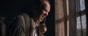 Movie still from “The Sisters Brothers” (2018), directed by Jacques Audiard – An older man is brushing his teeth with a wooden toothbrush; Extreme Close Up shot, Low angle
