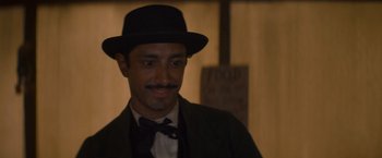 Movie still from “The Sisters Brothers” (2018), directed by Jacques Audiard – A man wearing a suit and a hat; Close Up shot, Over the shoulder angle