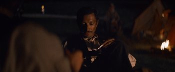 Movie still from “The Sisters Brothers” (2018), directed by Jacques Audiard – A man is looking at his cell phone in the dark; Close Up shot, Over the shoulder angle