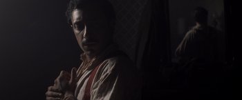 Movie still from “The Sisters Brothers” (2018), directed by Jacques Audiard – A man with a beard and mustache wearing a shirt and tie; Close Up shot, Low angle