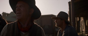 Movie still from “The Sisters Brothers” (2018), directed by Jacques Audiard – Two men wearing hats and one of them is wearing a hat; Close Up shot, Low angle