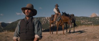 Movie still from “The Sisters Brothers” (2018), directed by Jacques Audiard – Two men on horses in a field with mountains in the background; Medium shot, Low angle