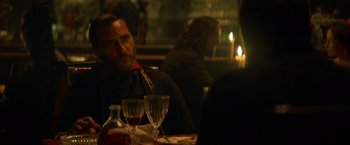 Movie still from “The Sisters Brothers” (2018), directed by Jacques Audiard – A man sitting at a table with a glass in front of him; Close Up shot, Over the shoulder angle