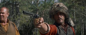 Movie still from “The Sisters Brothers” (2018), directed by Jacques Audiard – A man holding a gun in his right hand; Close Up shot, Low angle