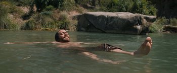Movie still from “The Sisters Brothers” (2018), directed by Jacques Audiard – A man in the water with a beard; Wide shot, High angle