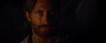 Movie still from “The Sisters Brothers” (2018), directed by Jacques Audiard – A person with a beard looking at the camera; Close Up shot, Over the shoulder angle