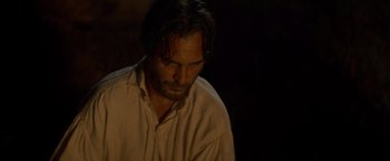 Movie still from “The Sisters Brothers” (2018), directed by Jacques Audiard – A person wearing a white shirt; Close Up shot, High angle