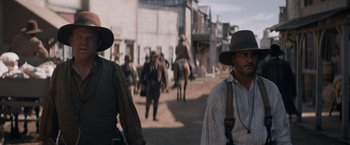 Movie still from “The Sisters Brothers” (2018), directed by Jacques Audiard – A group of people walking down a street; Medium shot, Low angle