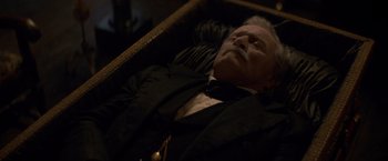 Movie still from “The Sisters Brothers” (2018), directed by Jacques Audiard – An older man in a suit laying in a chair; Close Up shot, High angle