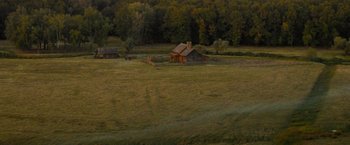 Movie still from “The Sisters Brothers” (2018), directed by Jacques Audiard – An old barn sits in the middle of an open field; Extreme Wide shot, High angle