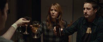 Movie still from “The Skeleton Twins” (2014), directed by Craig Johnson – A woman holding a bottle and a glass of beer; Medium shot, Over the shoulder angle