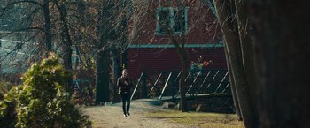 Movie still from “The Skeleton Twins” (2014), directed by Craig Johnson – A woman walking down a dirt road near a building; Extreme Wide shot, High angle