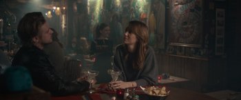 Movie still from “The Skeleton Twins” (2014), directed by Craig Johnson – A woman sitting at a table with a glass of wine; Medium shot, Over the shoulder angle