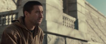 Movie still from “The Skeleton Twins” (2014), directed by Craig Johnson – A person wearing a jacket near a building; Close Up shot, Over the shoulder angle