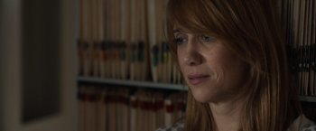 Movie still from “The Skeleton Twins” (2014), directed by Craig Johnson – A person sitting in front of a bookshelf; Close Up shot, Over the shoulder angle