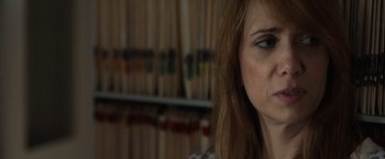 Movie still from “The Skeleton Twins” (2014), directed by Craig Johnson – A woman's face in front of a book shelf; Close Up shot, Over the shoulder angle