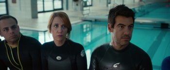 Movie still from “The Skeleton Twins” (2014), directed by Craig Johnson – A man and a woman in wetsuits next to a swimming pool; Medium shot, Over the shoulder angle