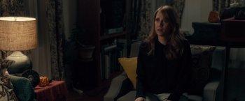Movie still from “The Skeleton Twins” (2014), directed by Craig Johnson – A woman sitting on a chair in a living room; Medium shot, Over the shoulder angle