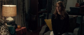 Movie still from “The Skeleton Twins” (2014), directed by Craig Johnson – A woman sitting on a chair in a living room; Medium shot, Over the shoulder angle