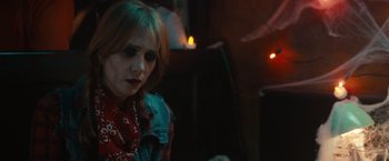 Movie still from “The Skeleton Twins” (2014), directed by Craig Johnson – A woman in a red and blue shirt is sitting in a dark room; Close Up shot, Over the shoulder angle