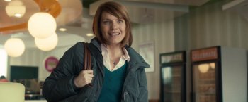 Movie still from “The Skeleton Twins” (2014), directed by Craig Johnson – A woman in a green shirt and a blue jacket holding a brown purse; Medium shot, Over the shoulder angle