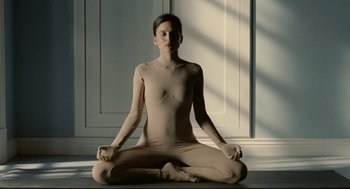 Movie still from “The Skin I Live In” (2011), directed by Pedro Almodóvar – A woman sitting on the ground in a yoga pose; Medium shot, High angle