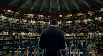 Movie still from “The Skin I Live In” (2011), directed by Pedro Almodóvar – A man standing in front of a group of people; Wide shot, Low angle