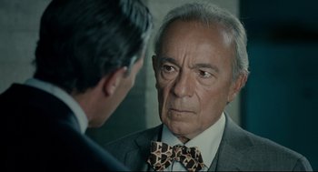 Movie still from “The Skin I Live In” (2011), directed by Pedro Almodóvar – An older man in a suit and tie looking at a younger man in a suit and tie; Close Up shot, Over the shoulder angle