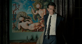 Movie still from “The Skin I Live In” (2011), directed by Pedro Almodóvar – A man standing in front of a painting; Medium shot, Low angle