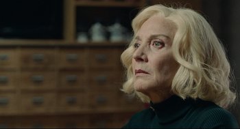 Movie still from “The Skin I Live In” (2011), directed by Pedro Almodóvar – An older woman with blonde hair looking to her left; Close Up shot, Over the shoulder angle