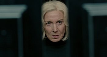 Movie still from “The Skin I Live In” (2011), directed by Pedro Almodóvar – An older woman with blonde hair looking through a fence; Close Up shot, Over the shoulder angle