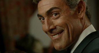 Movie still from “The Skin I Live In” (2011), directed by Pedro Almodóvar – A man smiling for the camera; Close Up shot, Over the shoulder angle