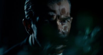 Movie still from “The Skin I Live In” (2011), directed by Pedro Almodóvar – A man's face in the dark; Close Up shot, Low angle