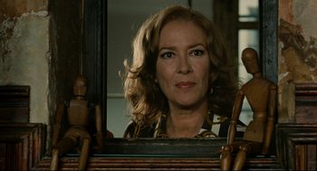 Movie still from “The Skin I Live In” (2011), directed by Pedro Almodóvar – A woman looking at her reflection in a mirror; Close Up shot, Low angle