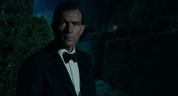 Movie still from “The Skin I Live In” (2011), directed by Pedro Almodóvar – A man in a tuxedo standing in front of a waterfall at night; Close Up shot, Low angle