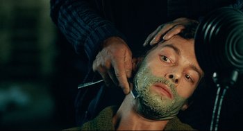 Movie still from “The Skin I Live In” (2011), directed by Pedro Almodóvar – A man getting his face shaved by a barber; Close Up shot, Over the shoulder angle