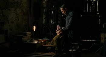 Movie still from “The Skin I Live In” (2011), directed by Pedro Almodóvar – A man sitting in front of another man in a chair; Medium shot, High angle