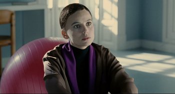 Movie still from “The Skin I Live In” (2011), directed by Pedro Almodóvar – A woman with a purple scarf sitting in a chair; Close Up shot, Over the shoulder angle
