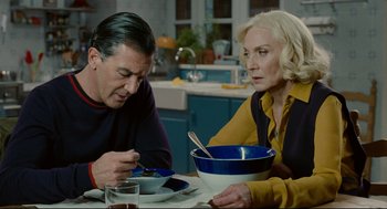 Movie still from “The Skin I Live In” (2011), directed by Pedro Almodóvar – A man and a woman sitting at a table with a bowl; Medium shot, Over the shoulder angle