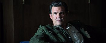 Movie still from “Sicario: Day of the Soldado” (2018), directed by Stefano Sollima – A person sitting in a chair wearing a jacket; Close Up shot, Low angle